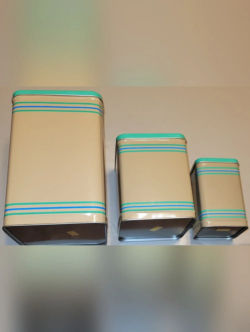 LASLO - Set of 3 Nesting Tan Metal Canisters with Green Lids and Stripes.